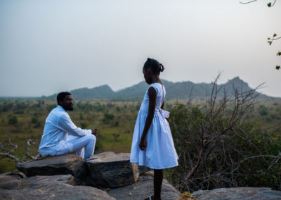 Kojo and Esi stand in an open field.