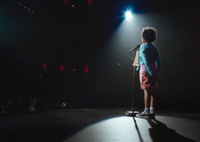 A little girl standing on stage.